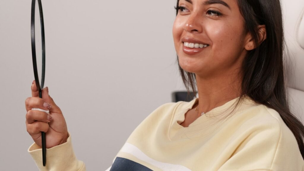 Jeune femme souriante se regardant dans un miroir