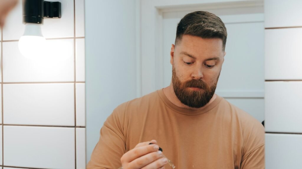 Homme appliquant un sérum devant le miroir de la salle de bain